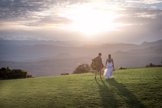 Bride And Groom Walking With A View Of The Drakensberg Mountains