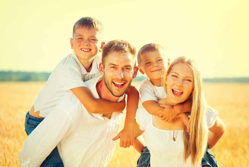 Happy young family on wheat summer field